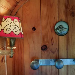 Hébergement insolite en bois avec lampe vintage et décor mural charmant.