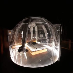 Hébergement insolite en bulle transparente, offrant une vue nocturne sur les étoiles.