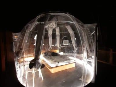 Hébergement insolite en bulle transparente, offrant une vue nocturne sur les étoiles.