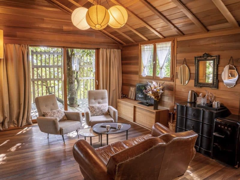 Chalet en bois chaleureux avec fauteuils confortables et vue sur la nature.