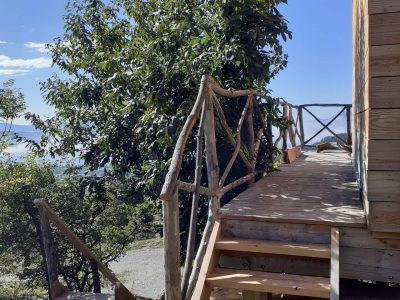Cabane en bois avec une terrasse en bois, entourée de verdure en Provence-Alpes-Côte dAzur.
