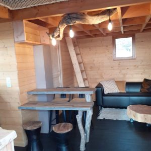 Cabane en bois moderne avec éclairage suspendu et mobilier en bois naturel.