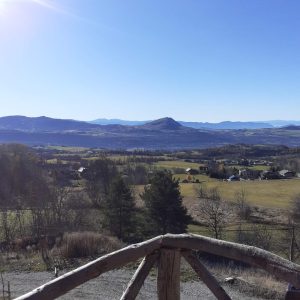 Cabane perchée avec vue panoramique sur les montagnes et la vallée verdoyante.