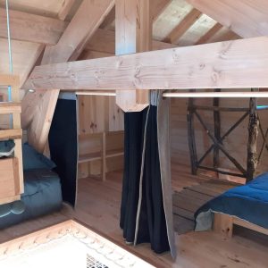 Cabane en bois dans les Alpes, avec lits douillets et poutres apparentes.