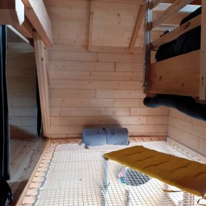 Cabane en bois avec un filet suspendu et un intérieur chaleureux en Provence-Alpes-Côte dAzur.