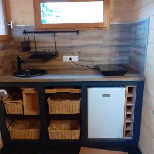 Cuisine en bois dun chalet insolite en Provence-Alpes-Côte dAzur, avec rangements en osier.