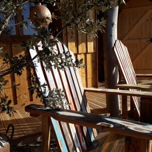 Hébergement insolite en bois avec chaises colorées et ambiance chaleureuse à Languedoc-Roussillon.