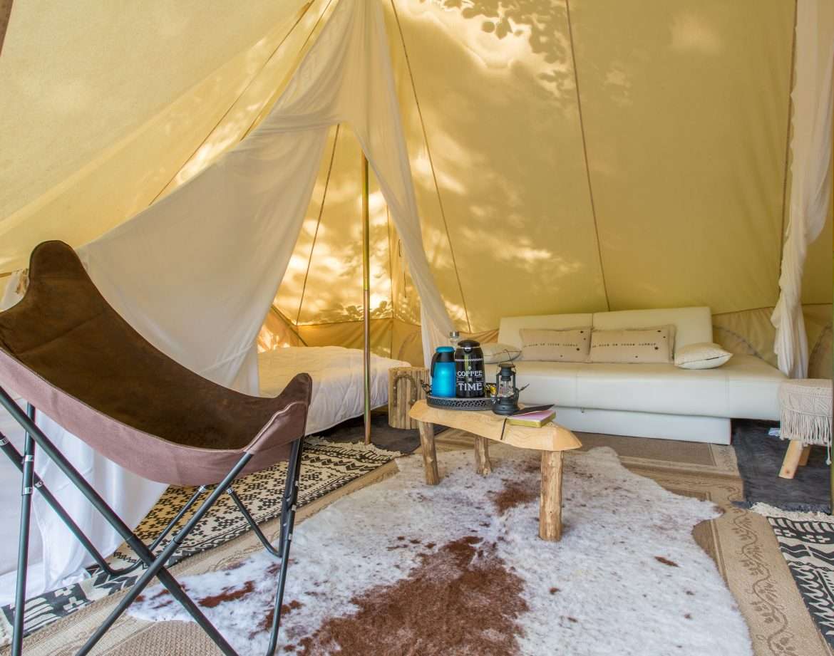 Tente glamping à Midi-Pyrénées, avec canapé confortable et décoration naturelle.