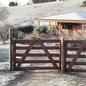 Cabane en bois avec terrasse, entourée de nature et de givre matinal.