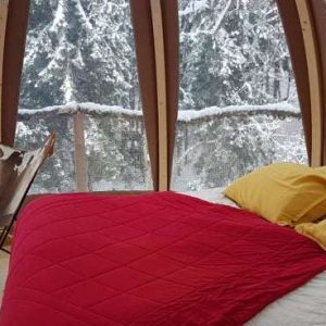 Hébergement insolite en bulle avec lit douillet et vue sur la neige en Auvergne-Rhône-Alpes.