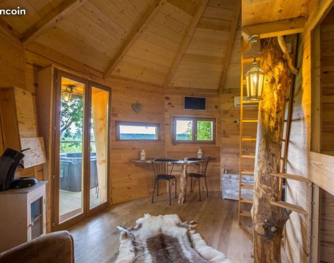 Cabane en bois chaleureuse avec vue panoramique et coin salon confortable.