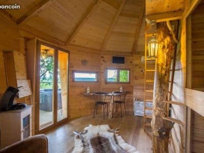 Cabane en bois chaleureuse avec vue panoramique et coin salon confortable.