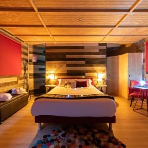Chambre dhôtel moderne avec un lit confortable et des murs en bois chaleureux.