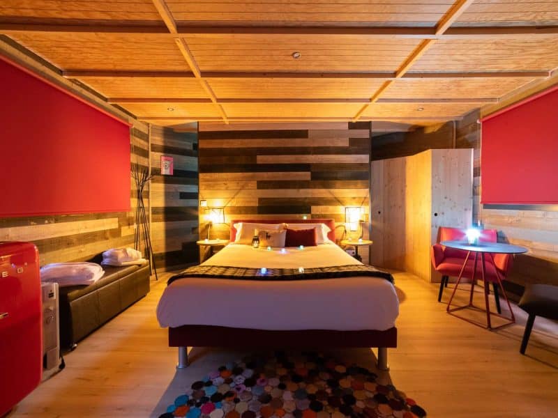 Chambre dhôtel moderne avec un lit confortable et des murs en bois chaleureux.