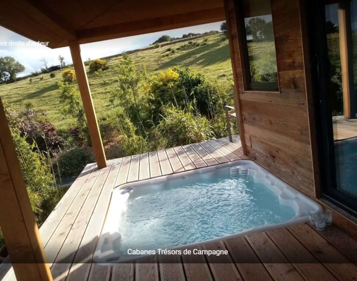 Cabane en bois avec jacuzzi, vue sur la nature verdoyante en Languedoc-Roussillon.