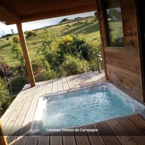 Cabane en bois avec jacuzzi, vue sur la nature verdoyante en Languedoc-Roussillon.