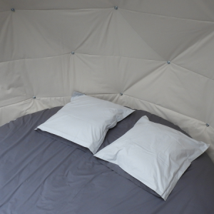 Dôme cosy à Grand-Est, avec un lit rond et des coussins moelleux.