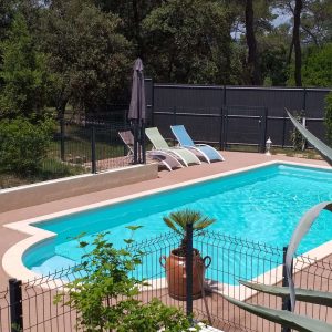Hébergement insolite avec piscine, entouré de verdure et chaises longues relaxantes.
