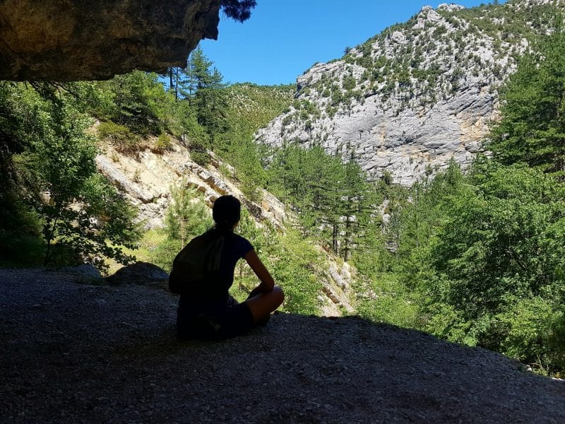 Hébergement en pleine nature, avec vue sur des montagnes verdoyantes et un ciel bleu.