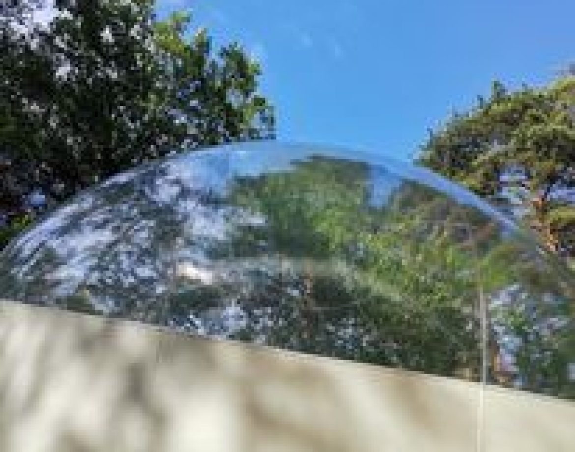 Bulle transparente en pleine nature, offrant une vue imprenable sur le ciel azur.