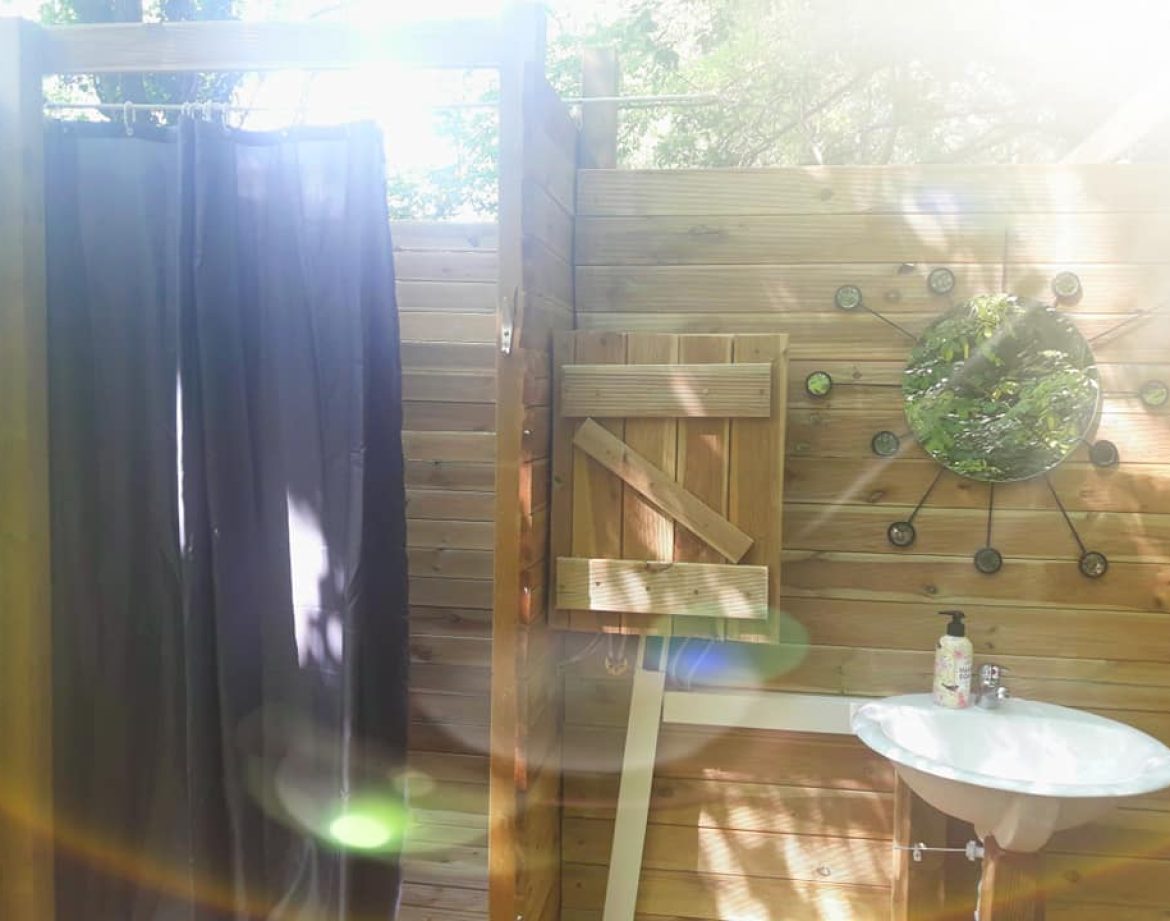 Douche extérieure en bois dans un hébergement insolite en Provence-Alpes-Côte dAzur.