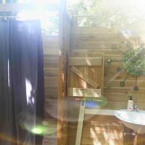 Douche extérieure en bois dans un hébergement insolite en Provence-Alpes-Côte dAzur.