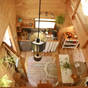 Cabane en bois avec une décoration chaleureuse et un éclairage suspendu.