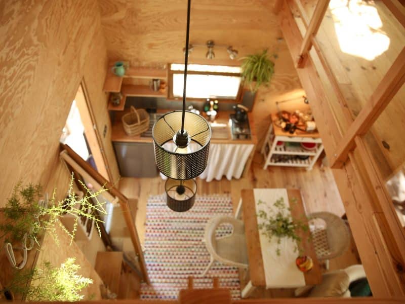 Cabane en bois avec une décoration chaleureuse et un éclairage suspendu.