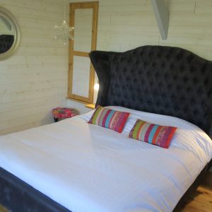 Chambre dhôtes insolite en Aquitaine avec un lit à tête de lit originale et colorée.