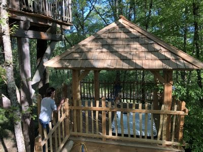 Cabane dans les arbres en Aquitaine, avec un toit en bois et vue sur la forêt.