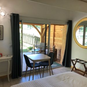 Hébergement insolite en Aquitaine : chambre moderne avec vue sur la terrasse en bois.