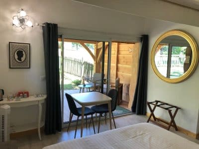 Hébergement insolite en Aquitaine : chambre moderne avec vue sur la terrasse en bois.