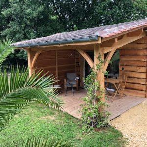 Cabane en bois à Aquitaine, avec terrasse et mobilier extérieur accueillant.
