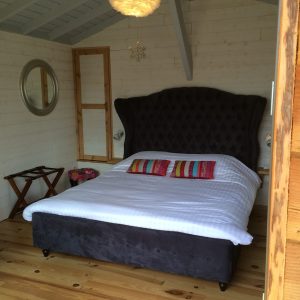 Chalet cosy en Aquitaine, avec un lit king-size et un éclairage suspendu élégant.