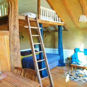 Hébergement insolite en Bretagne : cabane avec mezzanine et échelle en bois.