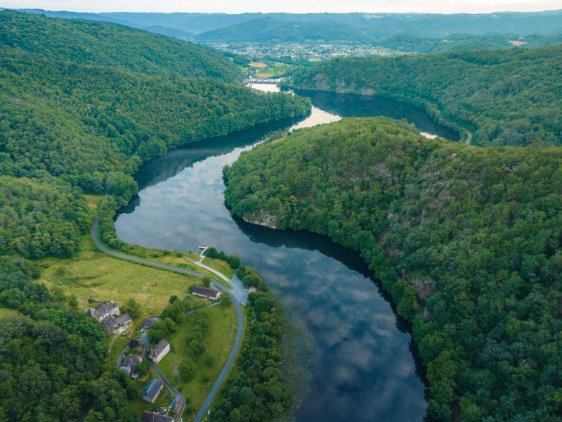 Charmant gîte en pleine nature, surplombant une rivière entourée de verdure.