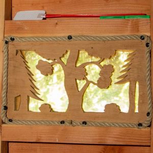 Cabane en bois avec une fenêtre décorée de motifs naturels en Auvergne.