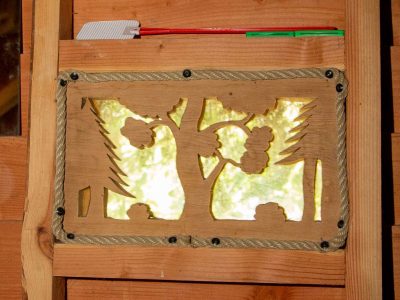 Cabane en bois avec une fenêtre décorée de motifs naturels en Auvergne.