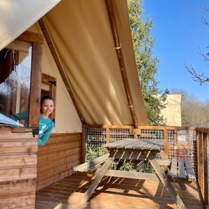 Cabane en bois avec terrasse, vue sur la nature et ciel bleu en Auvergne-Rhône-Alpes.