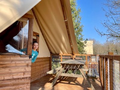Cabane en bois avec terrasse, vue sur la nature et ciel bleu en Auvergne-Rhône-Alpes.