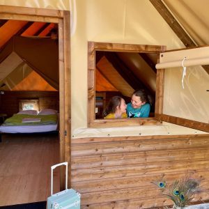 Tente lodge confortable en Auvergne-Rhône-Alpes, avec fenêtres en bois et ambiance chaleureuse.