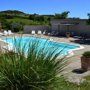Hébergement insolite en Languedoc-Roussillon avec piscine entourée de verdure.