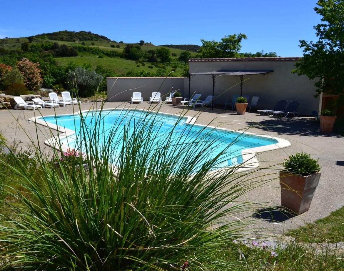 Hébergement insolite en Languedoc-Roussillon avec piscine entourée de verdure.