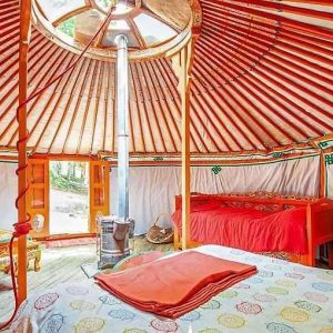 Yourte colorée en Auvergne, avec lits douillets et décor traditionnel vibrant.