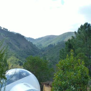 Hébergement insolite en bulle transparente, avec vue sur les montagnes verdoyantes.