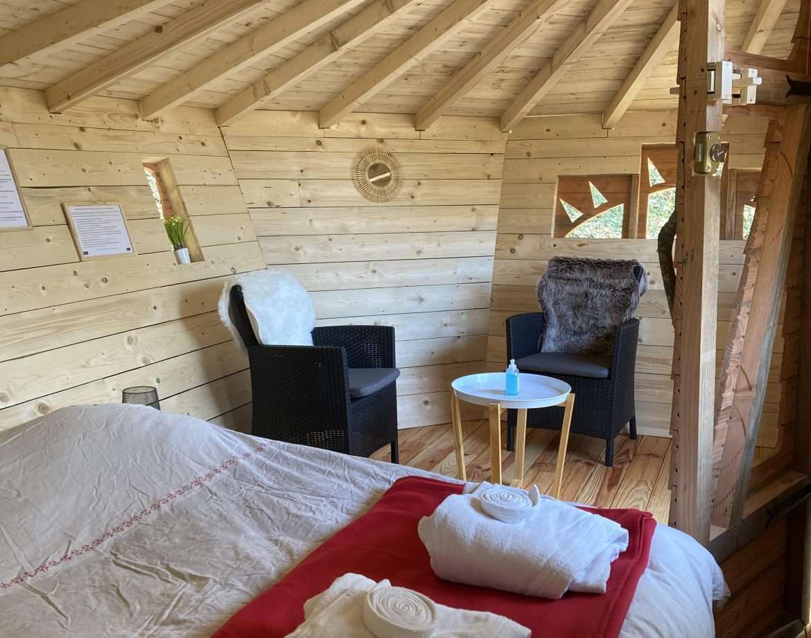 Cabane en bois cosy avec lit douillet et coin salon confortable.