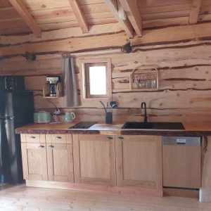 Charmant chalet en bois en Auvergne-Rhône-Alpes avec cuisine moderne et chaleureuse.