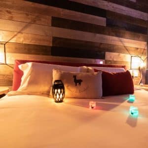 Chalet en bois en Bourgogne avec lit douillet et éclairage dambiance coloré.