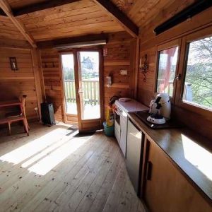 Cabane en bois cosy avec vue sur la nature et lumière naturelle.