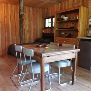 Cabane en bois à Nouvelle-Aquitaine, avec un intérieur chaleureux et mobilier en bois.